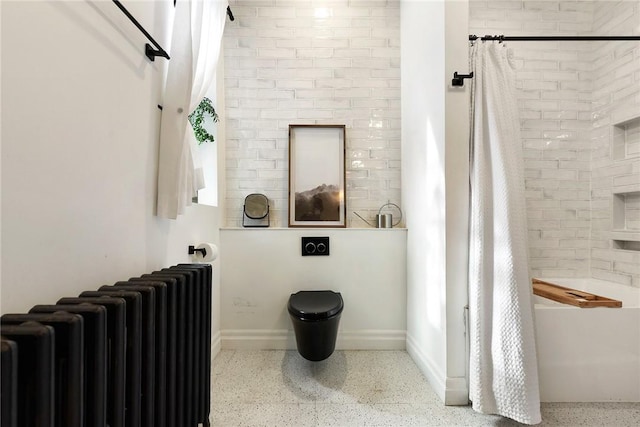 bathroom with baseboards, speckled floor, shower / bath combo with shower curtain, and radiator