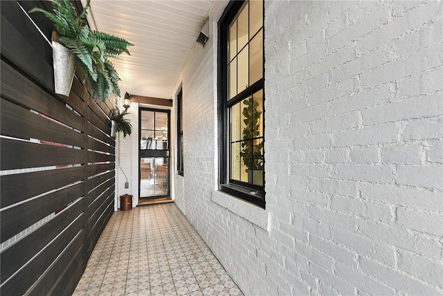 interior space with brick wall and tile patterned floors