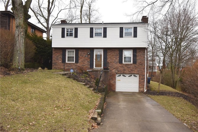 colonial house featuring a garage, brick siding, a chimney, and a front yard