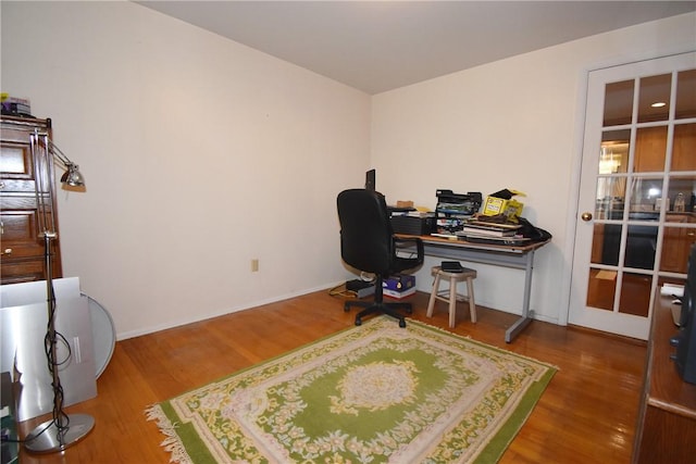 office area with baseboards and wood finished floors