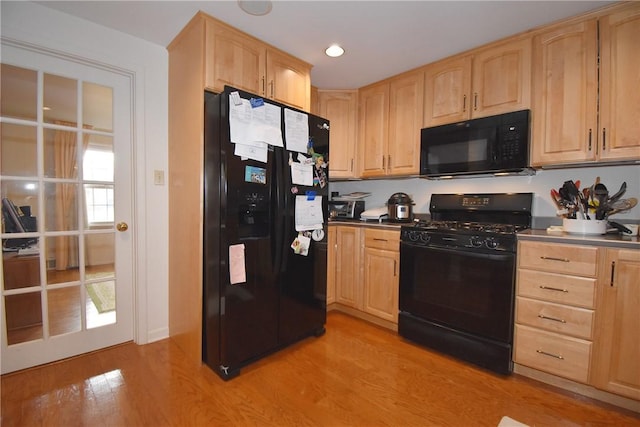 kitchen with black appliances and light brown cabinetry