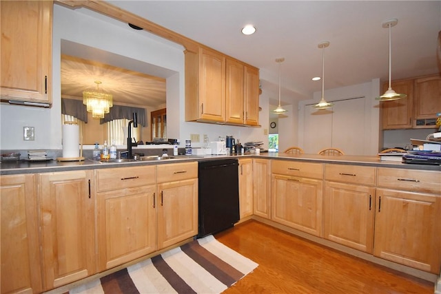 kitchen featuring dishwasher, light brown cabinetry, a sink, and pendant lighting