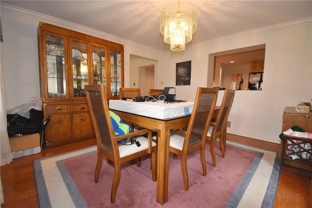 dining room with a chandelier, wood finished floors, and crown molding