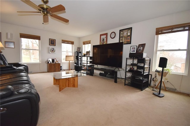 living room featuring light carpet, a ceiling fan, and a wealth of natural light