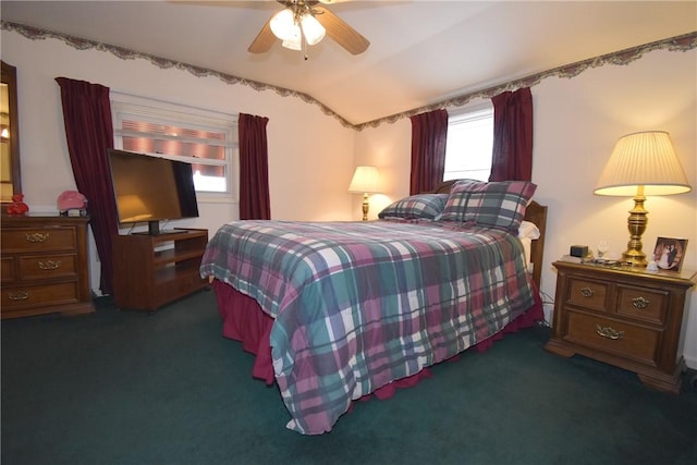 carpeted bedroom with vaulted ceiling and a ceiling fan