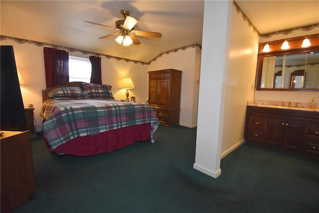 bedroom featuring a ceiling fan, baseboards, dark carpet, and a sink