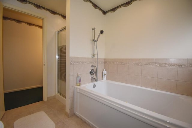 bathroom with a shower stall, a bath, and tile patterned floors