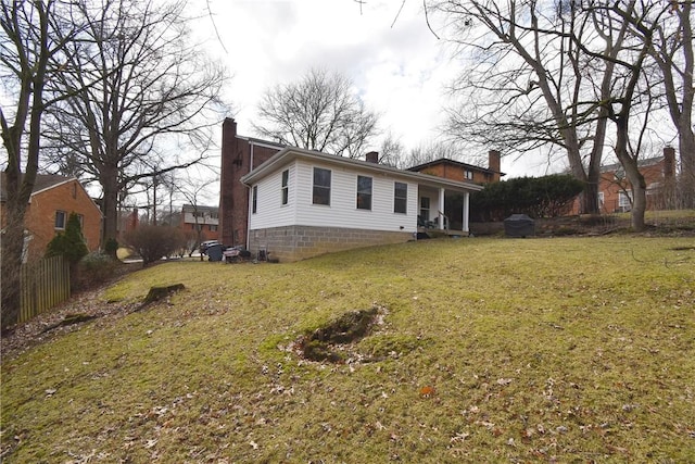 back of house with a yard and a chimney