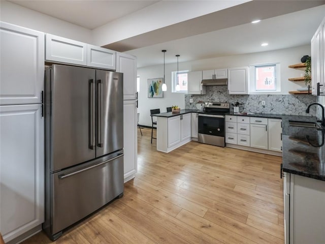 kitchen with white cabinets, light wood-style floors, stainless steel appliances, under cabinet range hood, and a sink