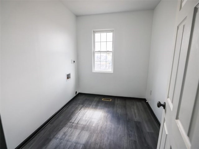 unfurnished room featuring dark wood-style floors, baseboards, and visible vents