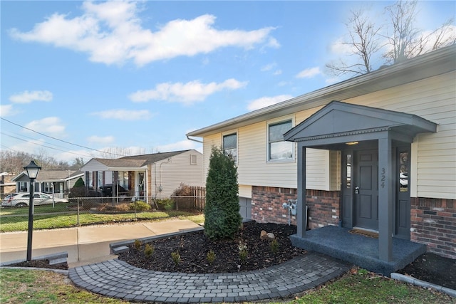 exterior space featuring brick siding and fence