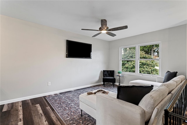 living room featuring dark wood-style floors, baseboards, and a ceiling fan