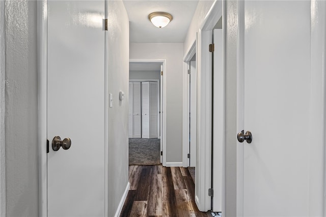 hallway with dark wood-style floors and baseboards