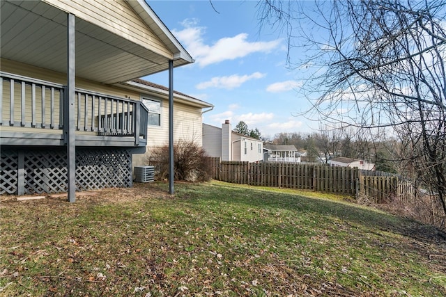 view of yard with central AC unit, fence, and a deck