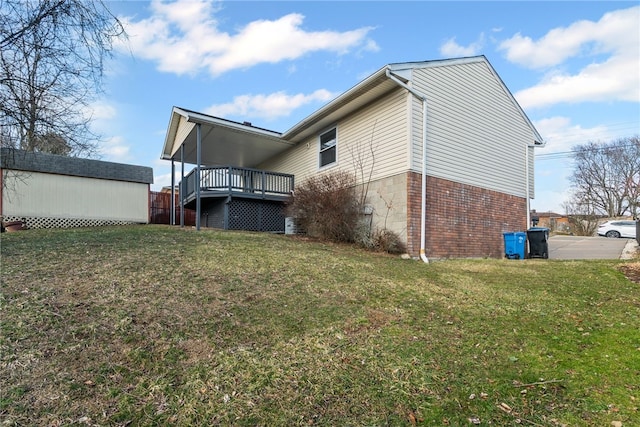 view of home's exterior with brick siding, an outbuilding, and a yard