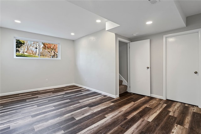 basement with recessed lighting, wood finished floors, baseboards, and stairs