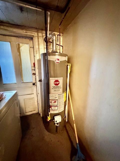 utility room featuring gas water heater and washer / dryer