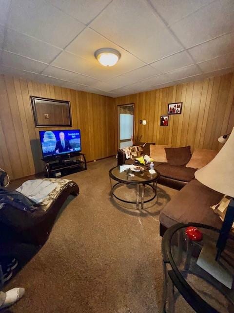 carpeted living room featuring wooden walls