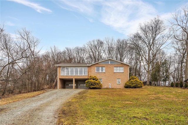 view of front facade featuring a garage, dirt driveway, a front lawn, and brick siding