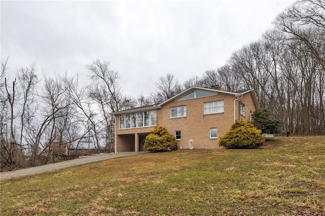 exterior space with a chimney, an attached garage, driveway, and a front lawn