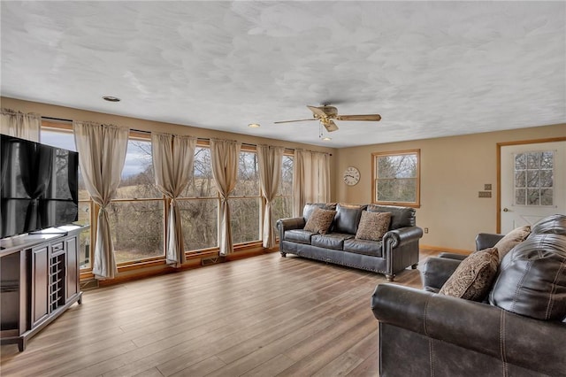 living room featuring ceiling fan, visible vents, and wood finished floors