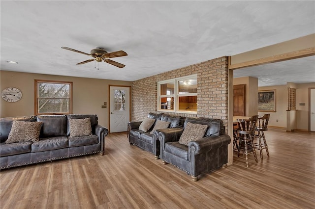 living room featuring ceiling fan, wood finished floors, and baseboards