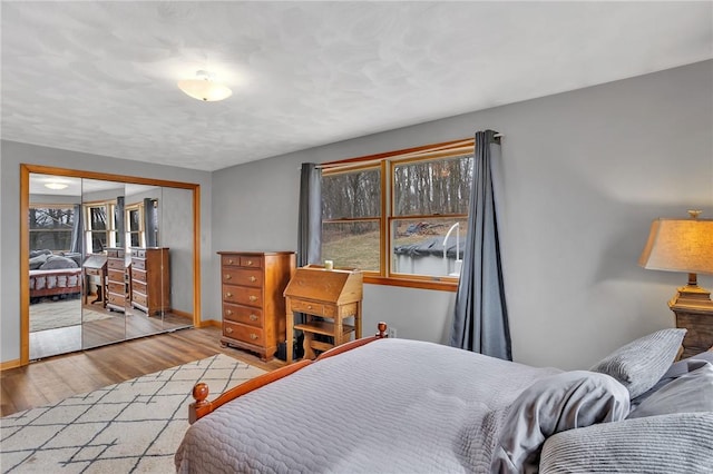 bedroom featuring a closet, baseboards, and wood finished floors