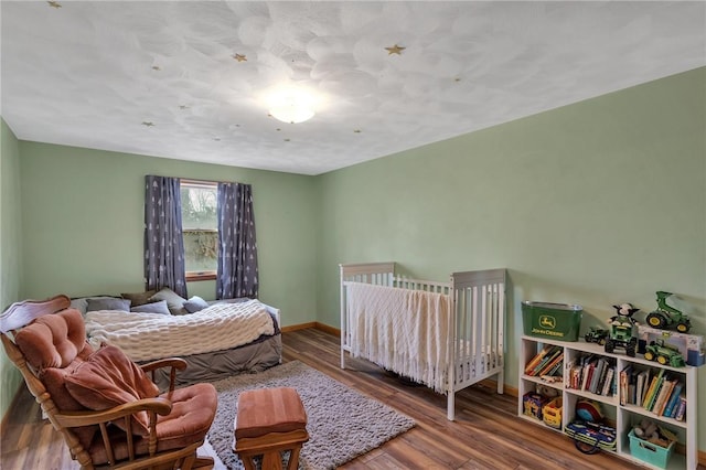 bedroom with baseboards and wood finished floors