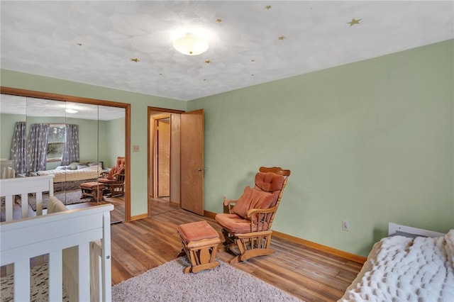 bedroom featuring a closet, baseboards, and wood finished floors