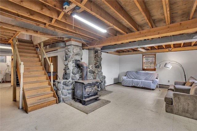 below grade area with a baseboard heating unit, stairway, and a wood stove