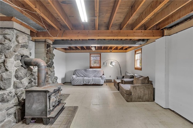 basement featuring a wood stove and tile patterned floors