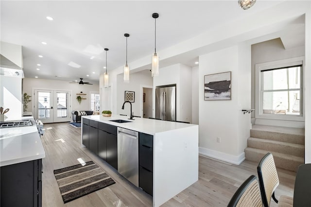 kitchen featuring modern cabinets, appliances with stainless steel finishes, dark cabinetry, french doors, and a sink