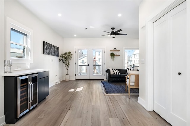 doorway with beverage cooler, french doors, recessed lighting, and light wood-style floors