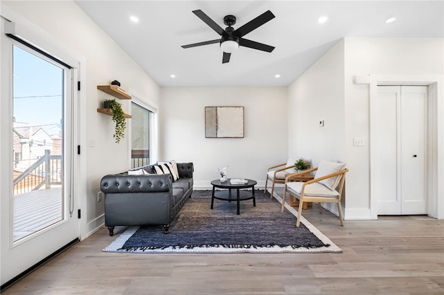 living area with baseboards, wood finished floors, and recessed lighting