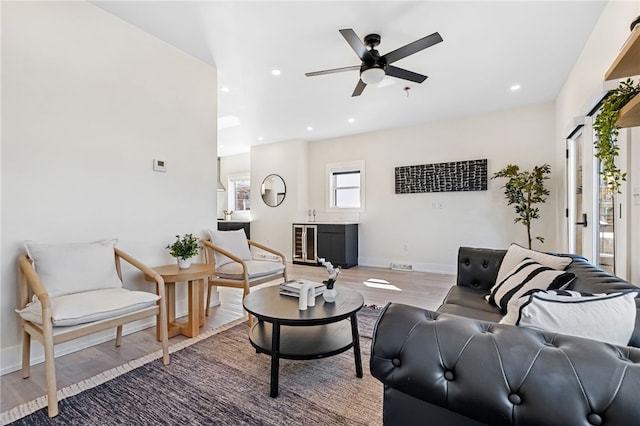 living area featuring baseboards, ceiling fan, wood finished floors, and recessed lighting