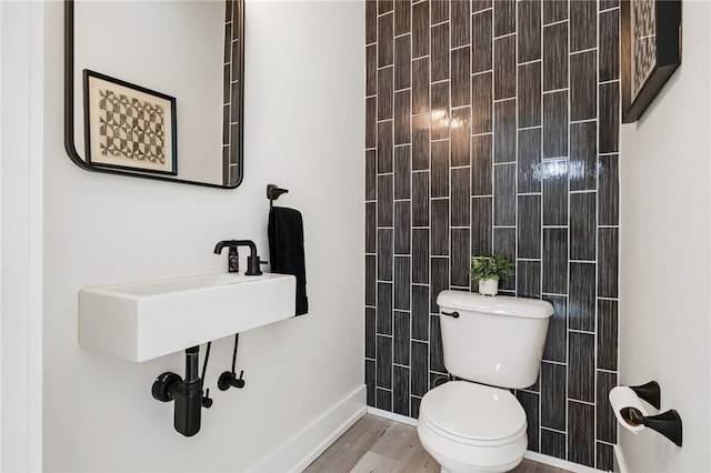 bathroom featuring wood finished floors, toilet, and baseboards