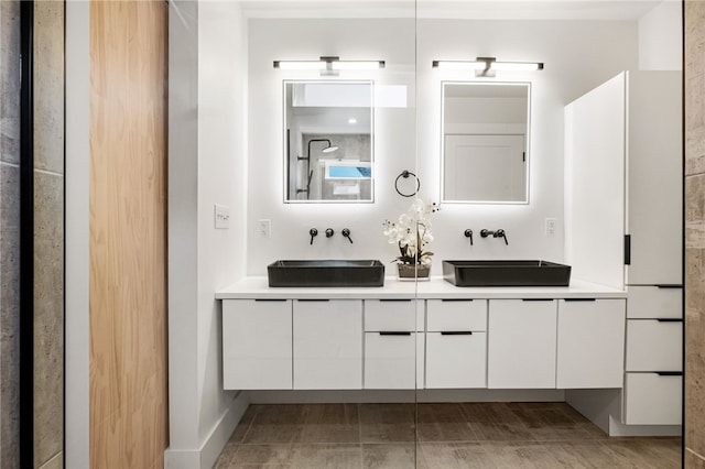 bathroom featuring double vanity, a sink, and baseboards