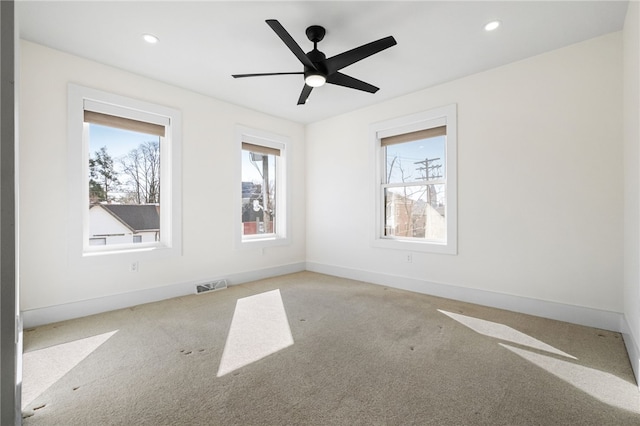 carpeted empty room with ceiling fan, recessed lighting, visible vents, and baseboards