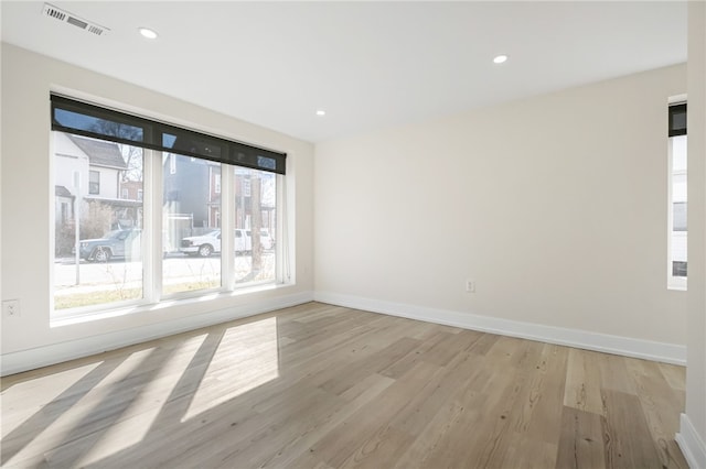 unfurnished room with baseboards, light wood finished floors, visible vents, and recessed lighting