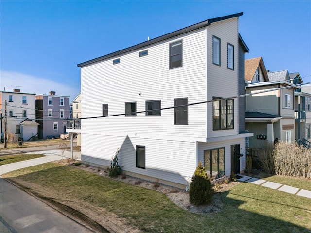 view of home's exterior with a lawn and a residential view