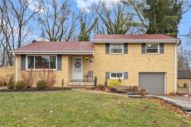 tri-level home with an attached garage, brick siding, a shingled roof, driveway, and a front yard