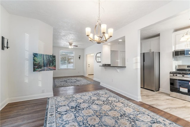 kitchen with appliances with stainless steel finishes, white cabinets, and light wood finished floors