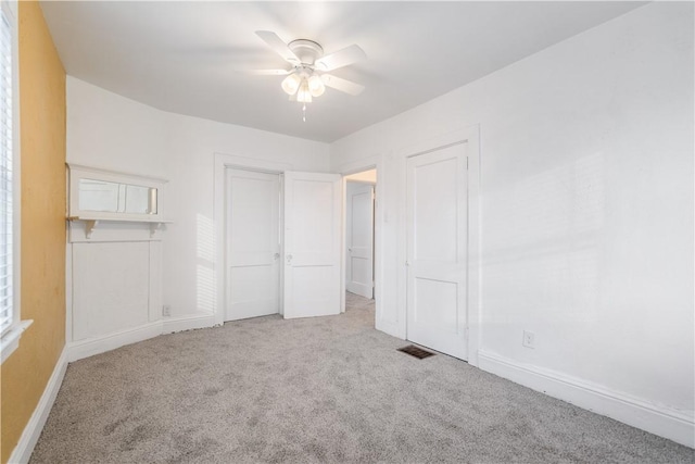 unfurnished bedroom featuring carpet floors, visible vents, ceiling fan, and baseboards