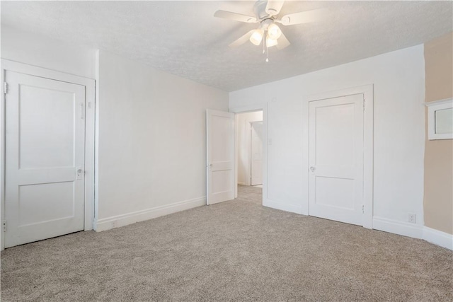 unfurnished bedroom with a ceiling fan, carpet flooring, a textured ceiling, and baseboards