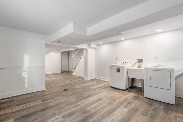 laundry room featuring recessed lighting, baseboards, wood finished floors, and washing machine and clothes dryer