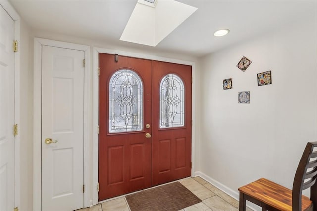 entrance foyer with a skylight, baseboards, and french doors