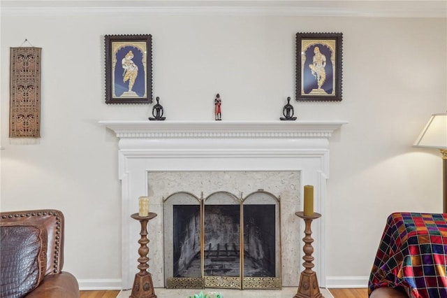 details with a fireplace with flush hearth, crown molding, and baseboards