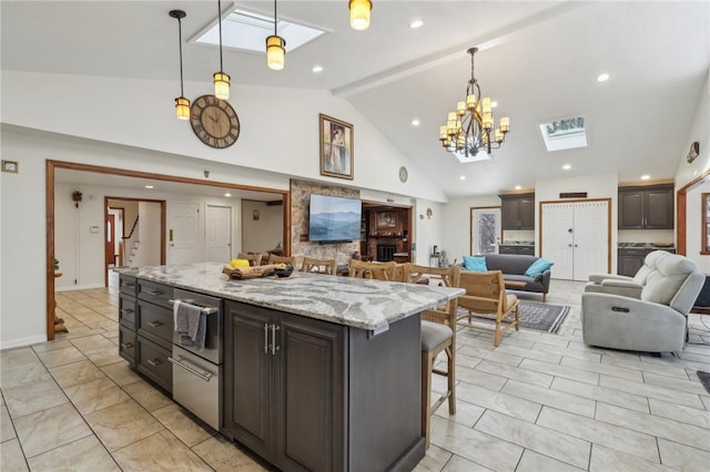 kitchen with a breakfast bar, a skylight, open floor plan, and hanging light fixtures