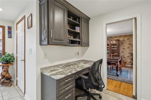 office space with light tile patterned flooring and built in study area