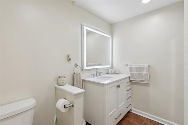 bathroom with tile patterned flooring, vanity, toilet, and baseboards